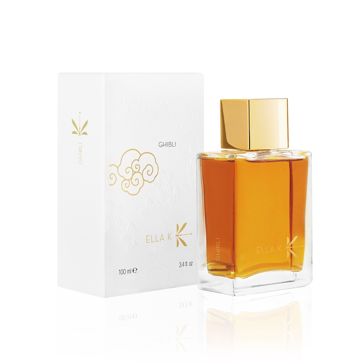 Flacon de parfum Ghibli d’Ella K en verre givré blanc avec capuchon doré, présenté à côté de son étui illustré blanc.