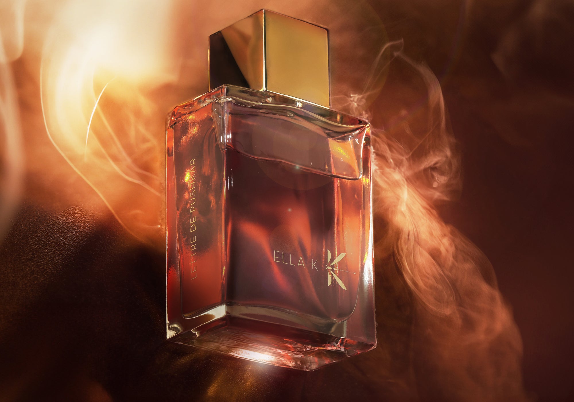 Flacon Lettre de Pushkar d’Ella K avec bouchon doré, baigné de lumière chaude et entouré de fumée montante – symbole de sensualité et profondeur orientale.