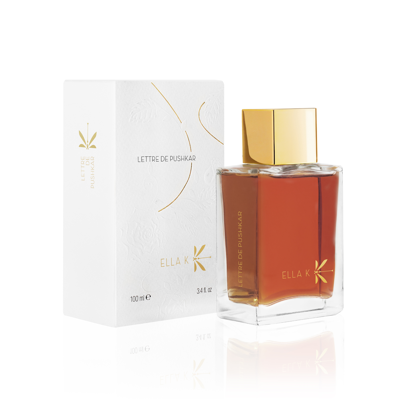Flacon de parfum Lettre de Pushkar d’Ella K avec capuchon doré, présenté à côté de son étui illustré blanc.
