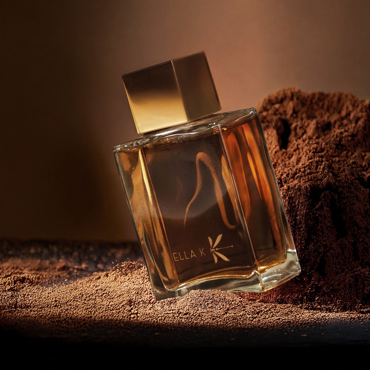 Le flacon du parfum – Mélodie de l’Altaï – de Ella K repose sur une surface terreuse texturée. La lumière chaude fait briller les nuances dorées et ambrées, évoquant la force naturelle des montagnes de l’Altaï.