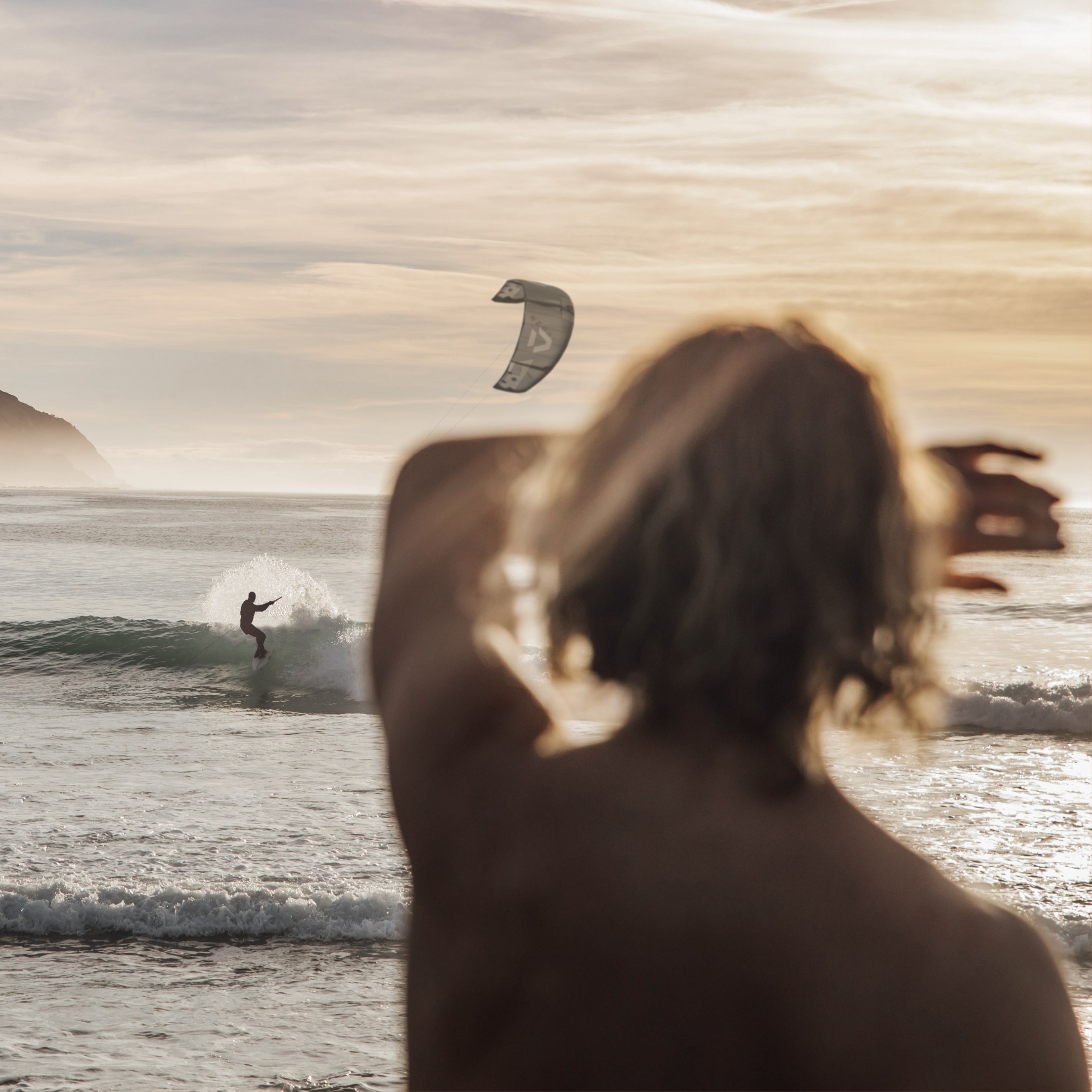 Un surfeur dompte les vagues sous le regard d’un observateur – une scène dynamique et charismatique, illustrant l’énergie captivante de Musc K.
