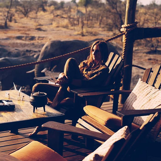 Sonia Constant sur une terrasse de lodge en Afrique, avec des éléphants en arrière-plan – source d’inspiration pour Reflet sur l’Okavango.