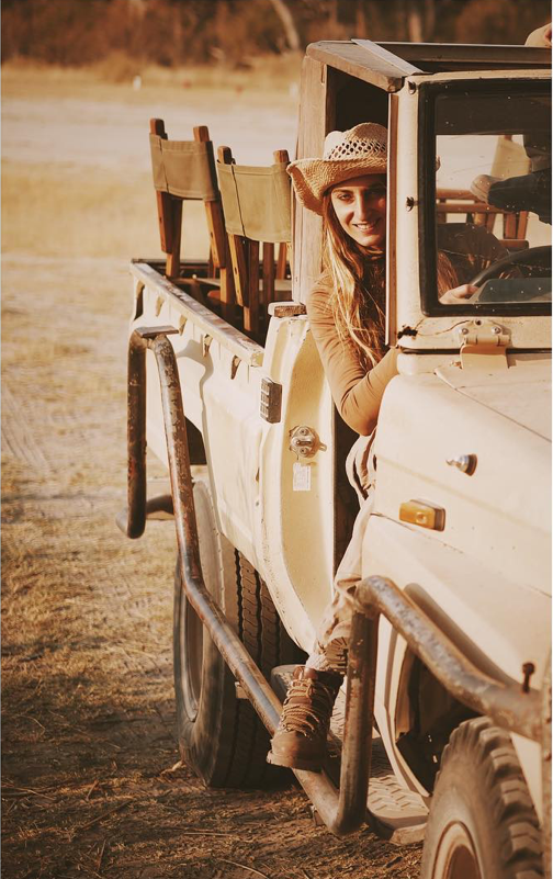 Sonia Constant au volant d’un 4x4 de safari, le sourire aux lèvres – en route vers de nouvelles aventures olfactives avec Ella K Parfums.