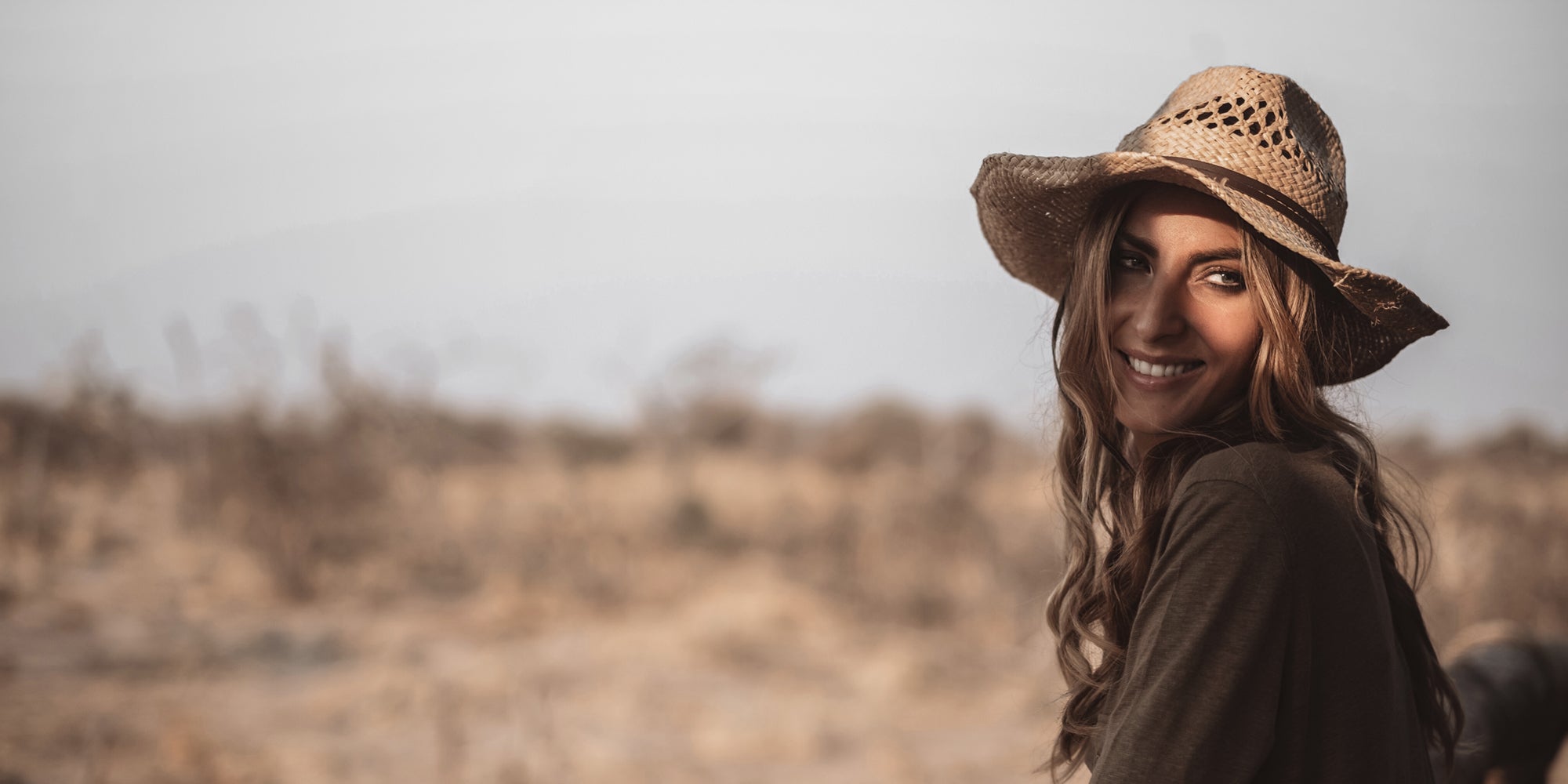 Sonia Constant avec un chapeau de paille dans la lumière dorée de la savane – instant de voyage capturé dans l’esprit d’Ella K.