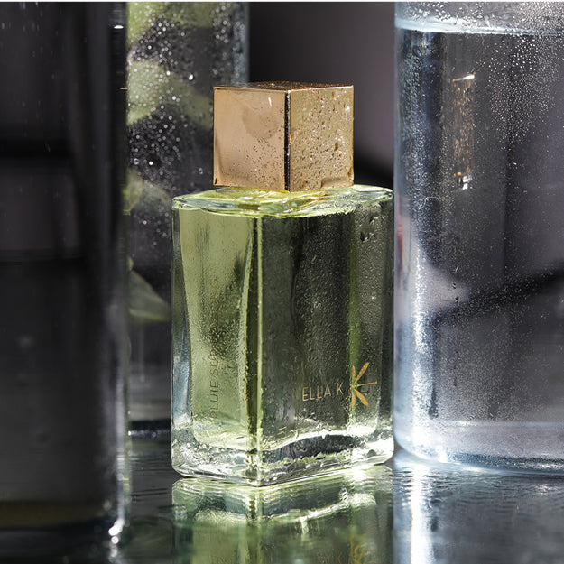 Flacon de Pluie sur Ha Long au parfum rafraîchissant, entouré de verre et de gouttes de condensation – symbole de fraîcheur et de pluie tropicale