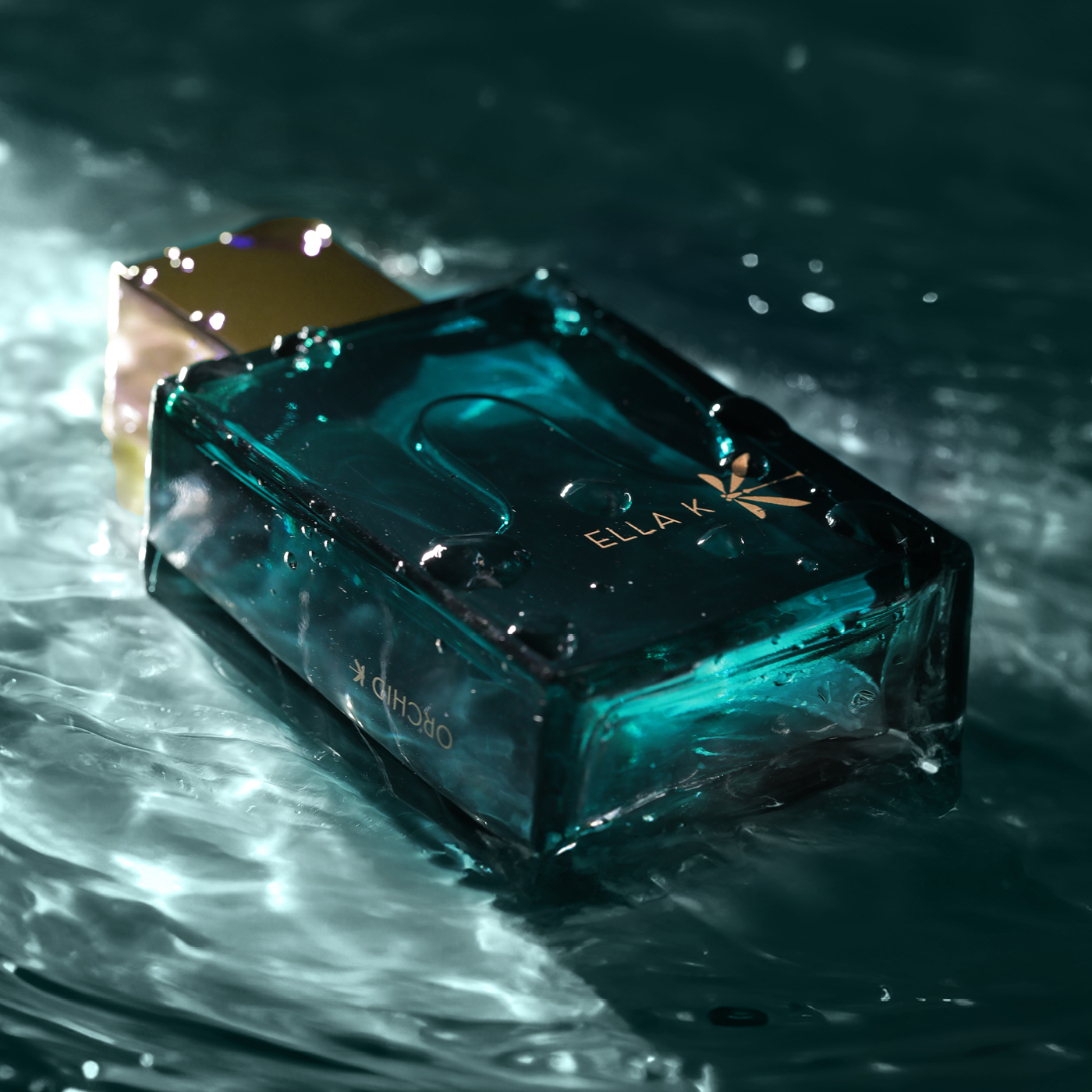 Flacon de parfum Orchid K en verre turquoise, immergé dans l’eau scintillante – symbole de fraîcheur et de profondeur